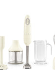 Cream Smeg hand mixer including a blender, chopper, and whisk on a white background
