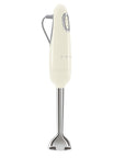 Side view of cream Smeg hand mixer displayed on a white background
