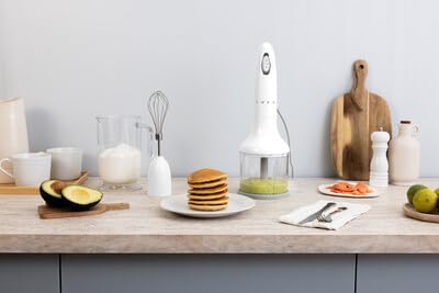 Kitchen counter with a blender, pancakes, and various kitchen items.