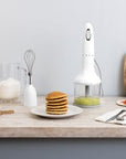 Kitchen counter with a blender, pancakes, and various kitchen items.