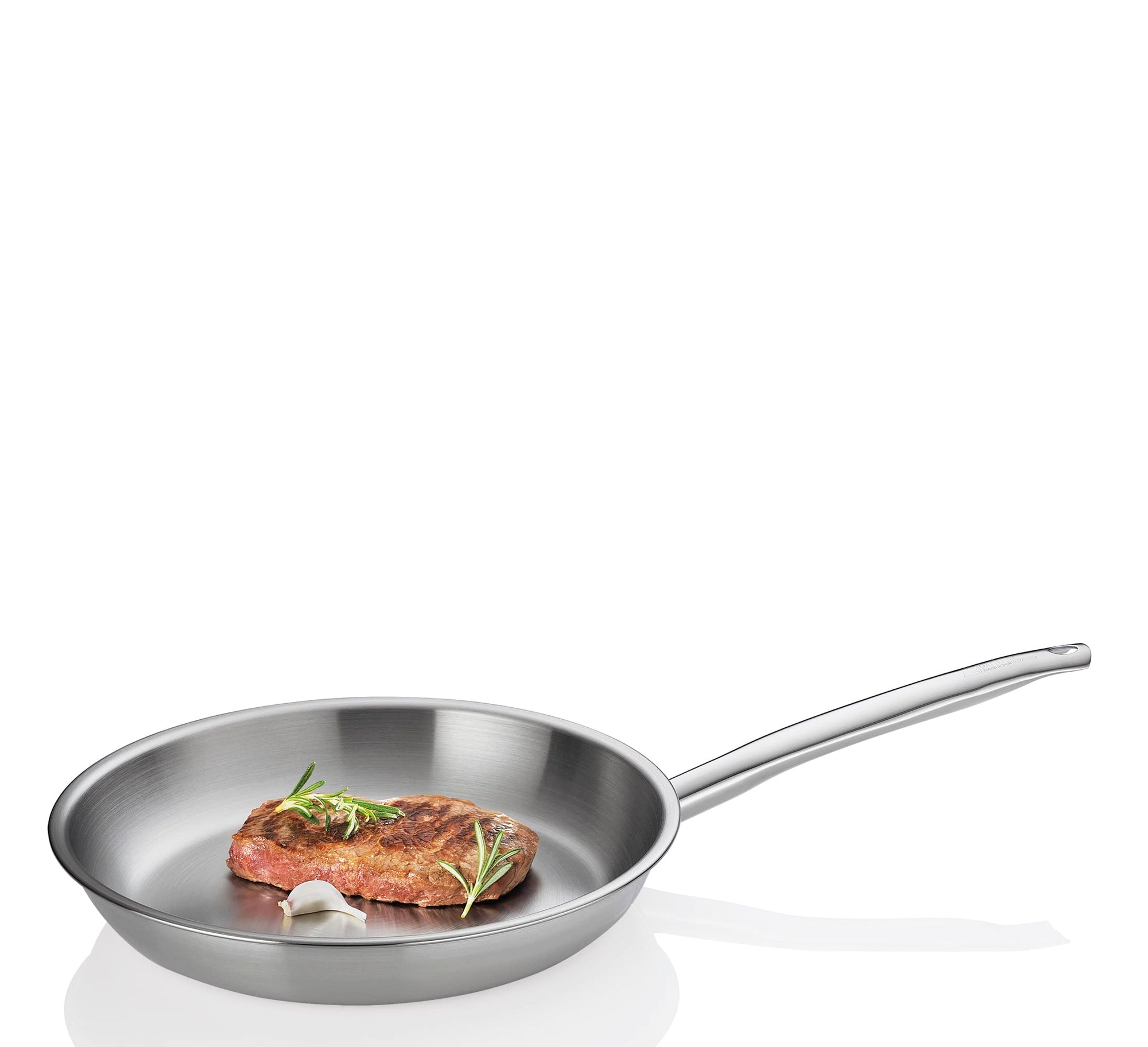 Stainless Steel frying pan with cooked steak, herb, and garlic displayed on a white background