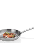 Stainless Steel frying pan with cooked steak, herb, and garlic displayed on a white background