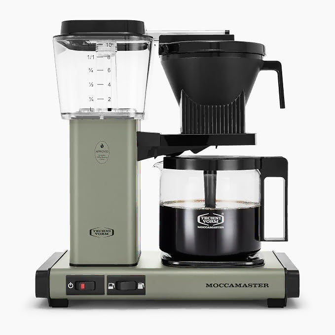 Front view of green Moccamaster coffee maker with coffee filled carafe on a white background