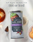 Tea canister labeled 'All Day Earl Grey' with a cup of tea, cookies, and a tea bag on a marble surface.