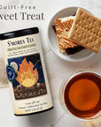 S'mores tea packaging with a cup of tea, graham crackers, and marshmallows on a marble surface.