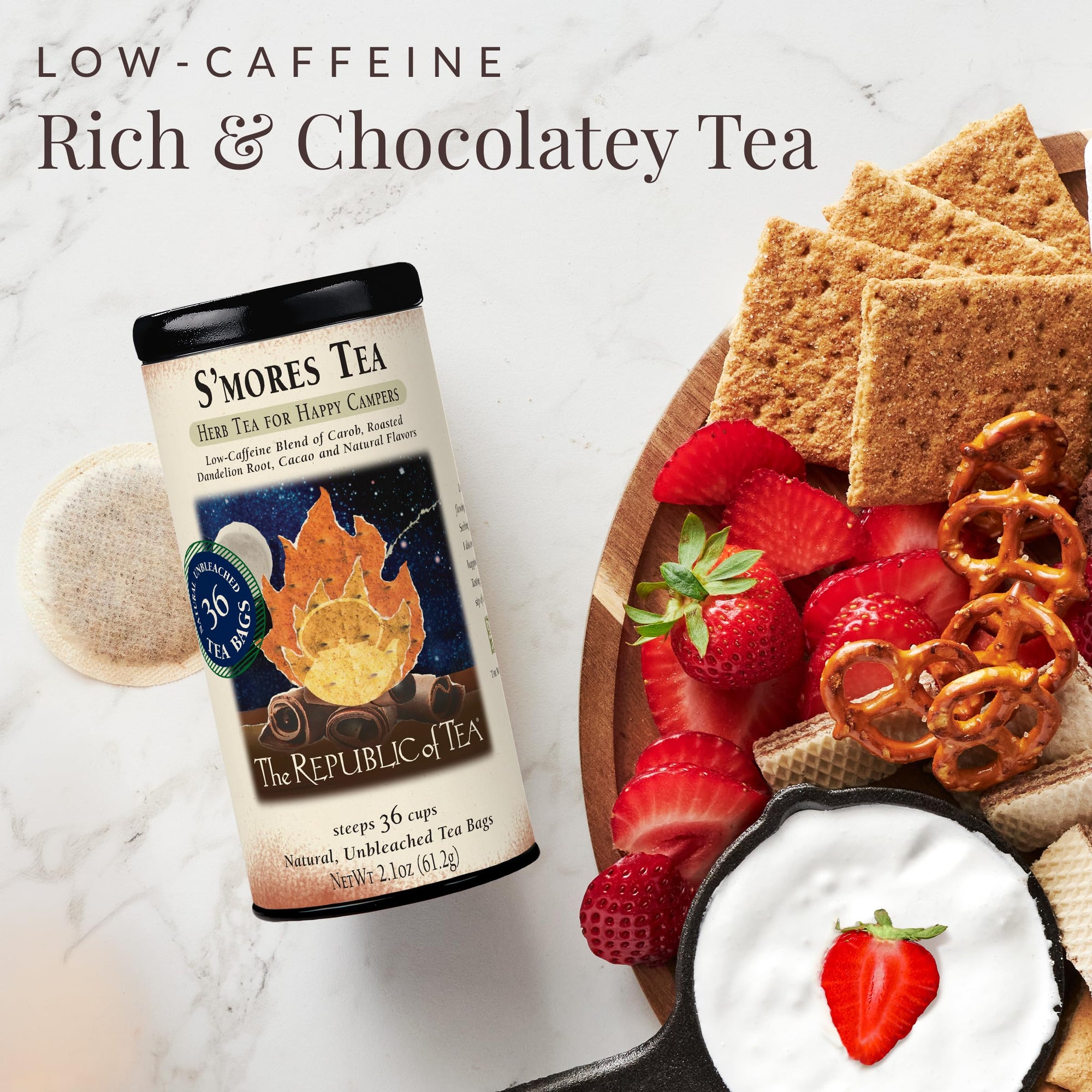 S'mores tea package with a plate of strawberries, graham crackers, and pretzels on a marble background.