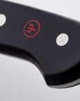 Close-up of a knife blade with a visible brand logo on a light gray background
