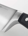 Close-up of the hilt of the Wüsthof Classic knife on a light gray background