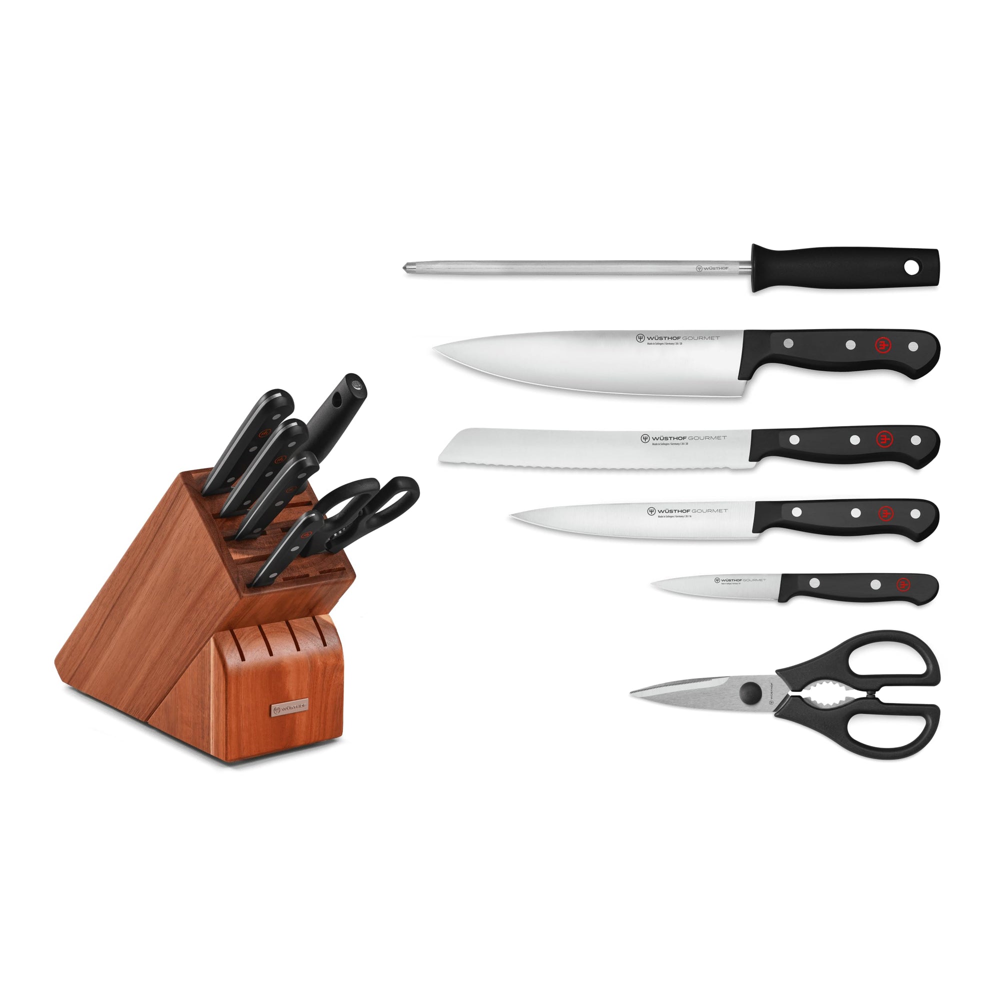 Set of knives and a pair of scissors next to a knife block set on a white background